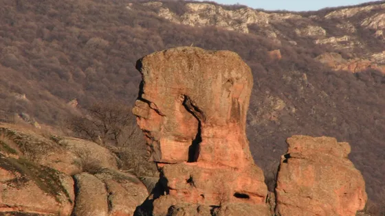 Скална фигура, огряна в червено от ниското слънце